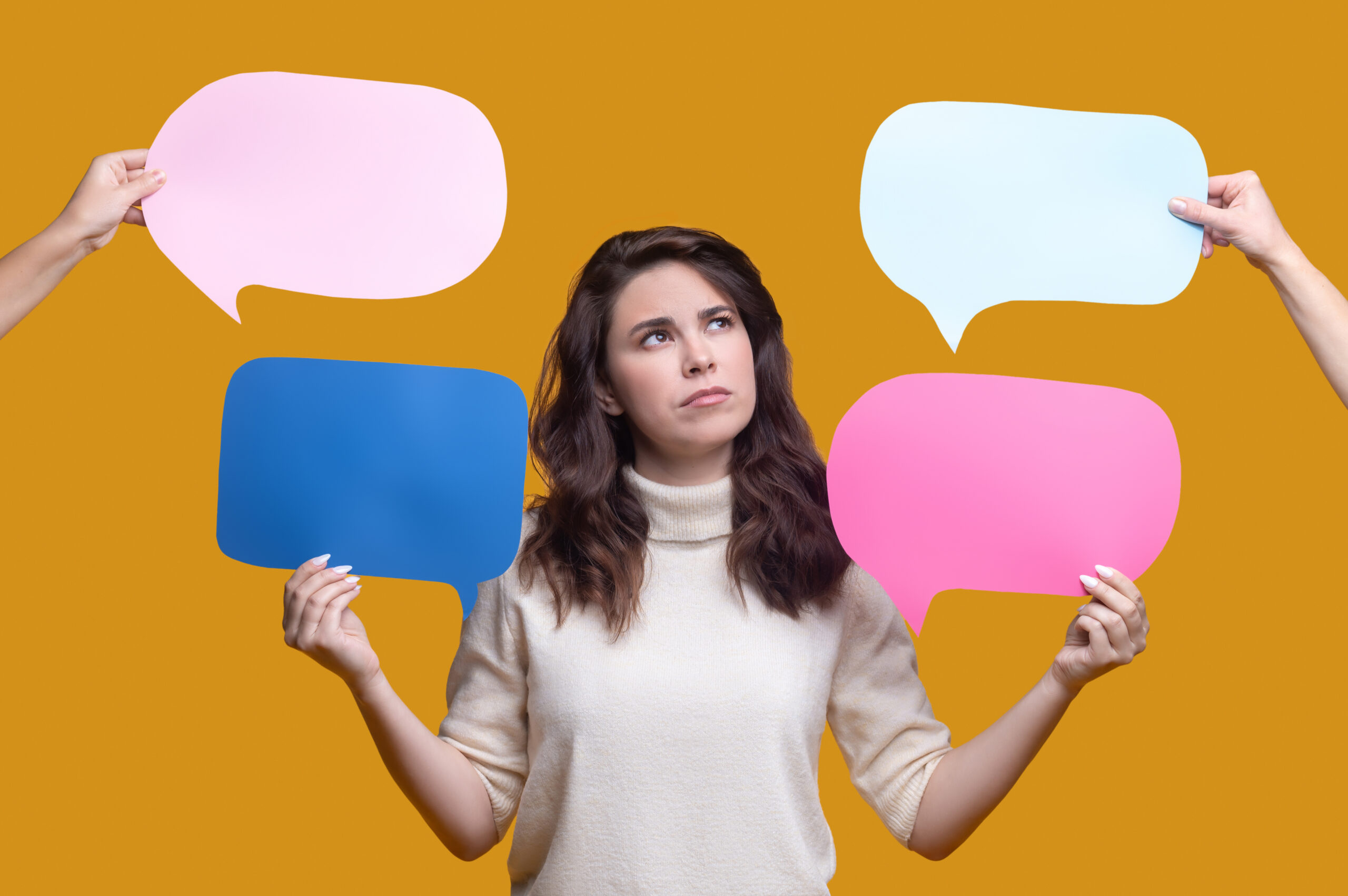Waist-up portrait of a serious thoughtful young beautiful woman holding empty question and answer signs